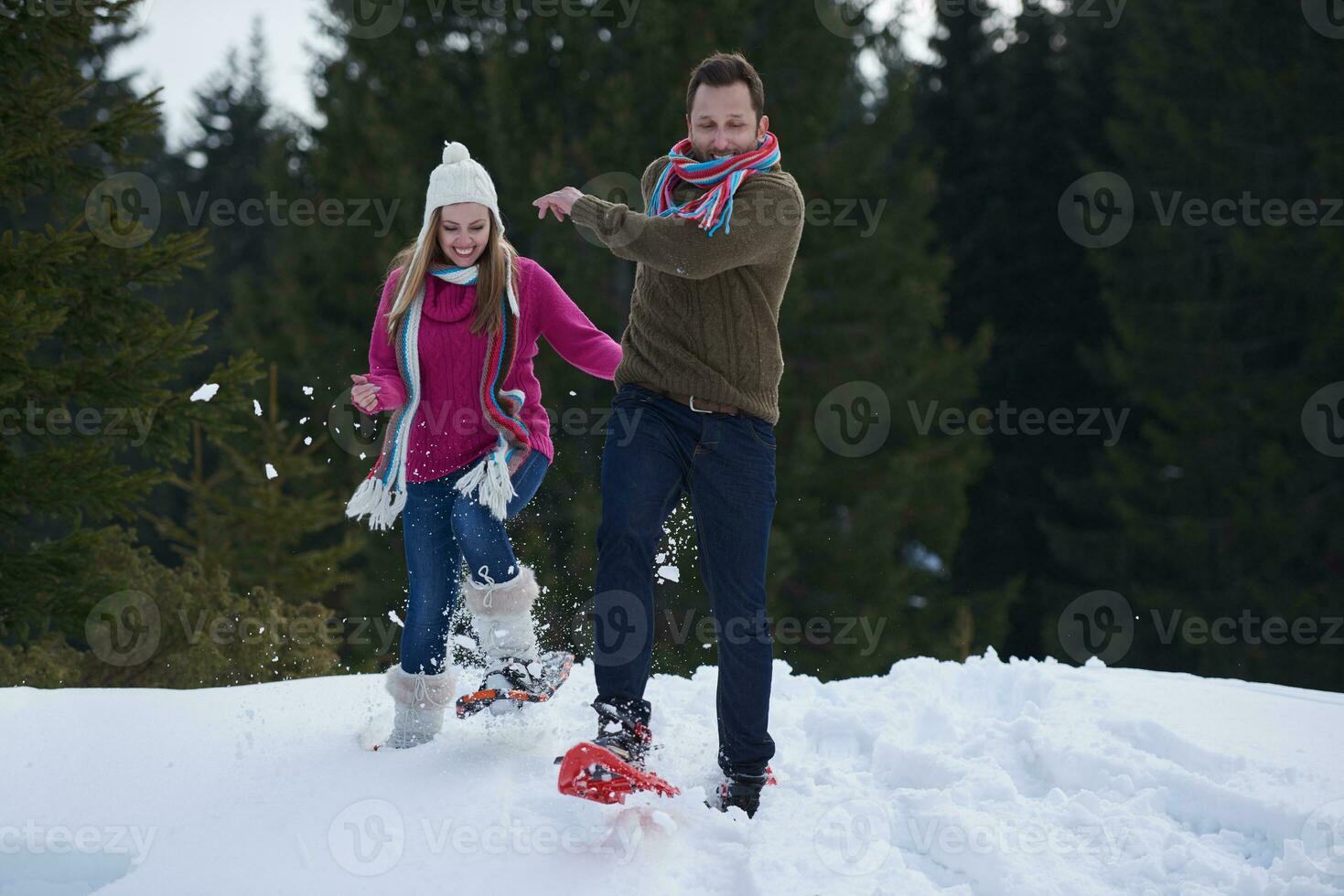 couple having fun and walking in snow shoes photo