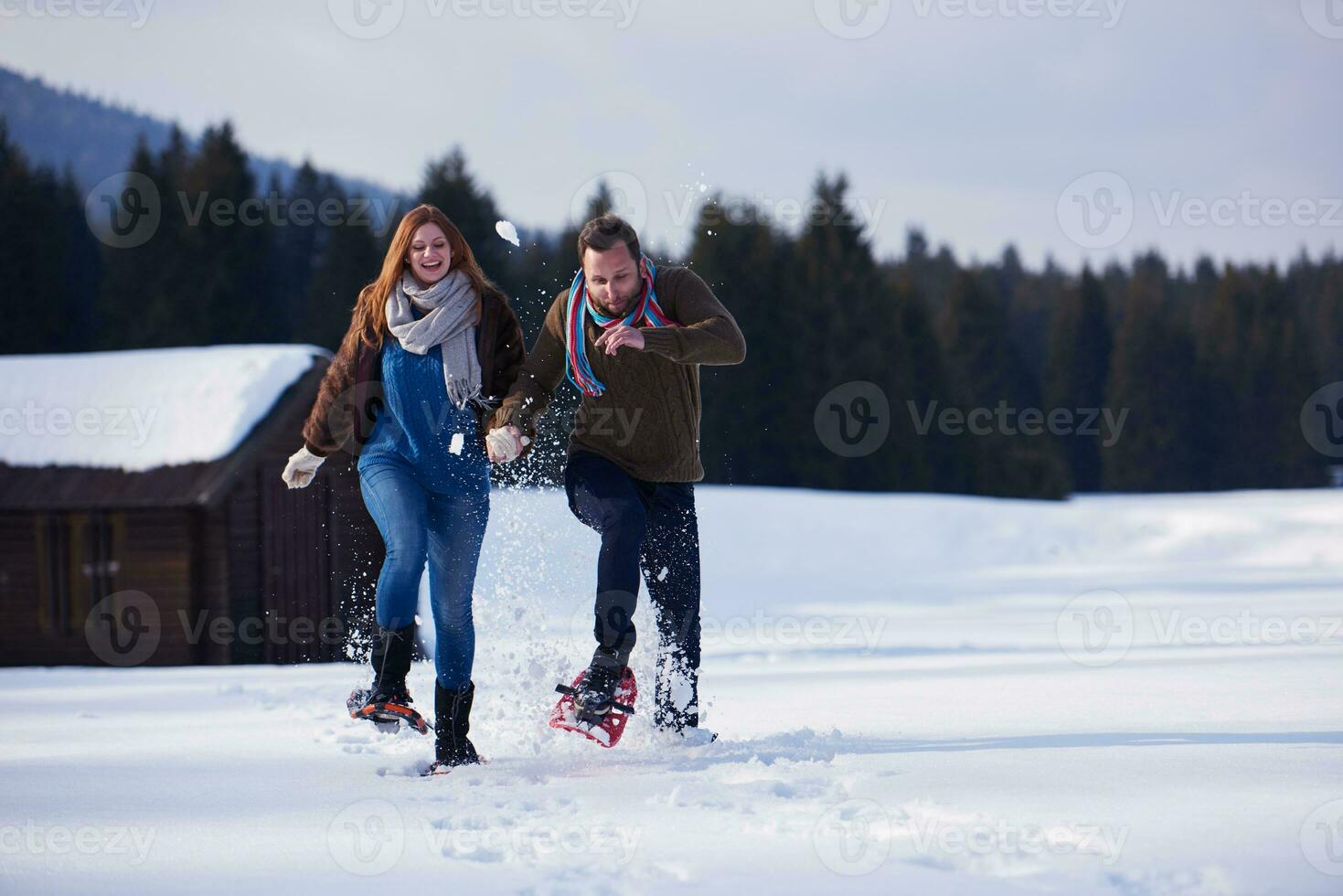 couple having fun and walking in snow shoes photo