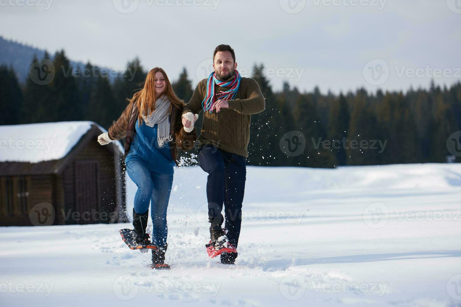 couple having fun and walking in snow shoes photo