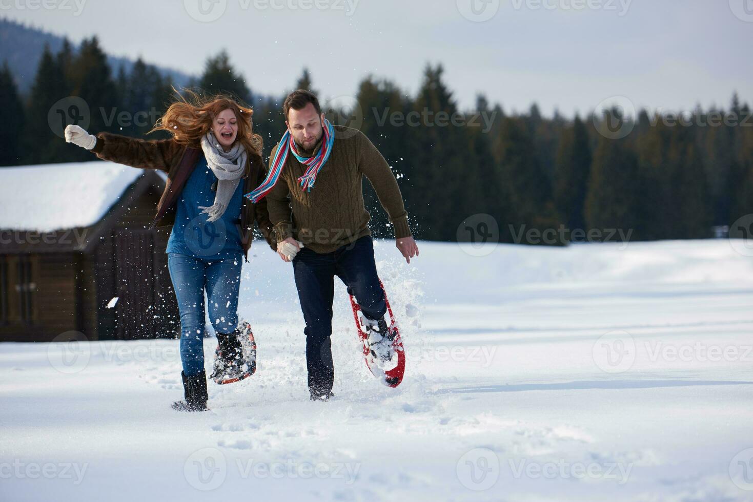 couple having fun and walking in snow shoes photo