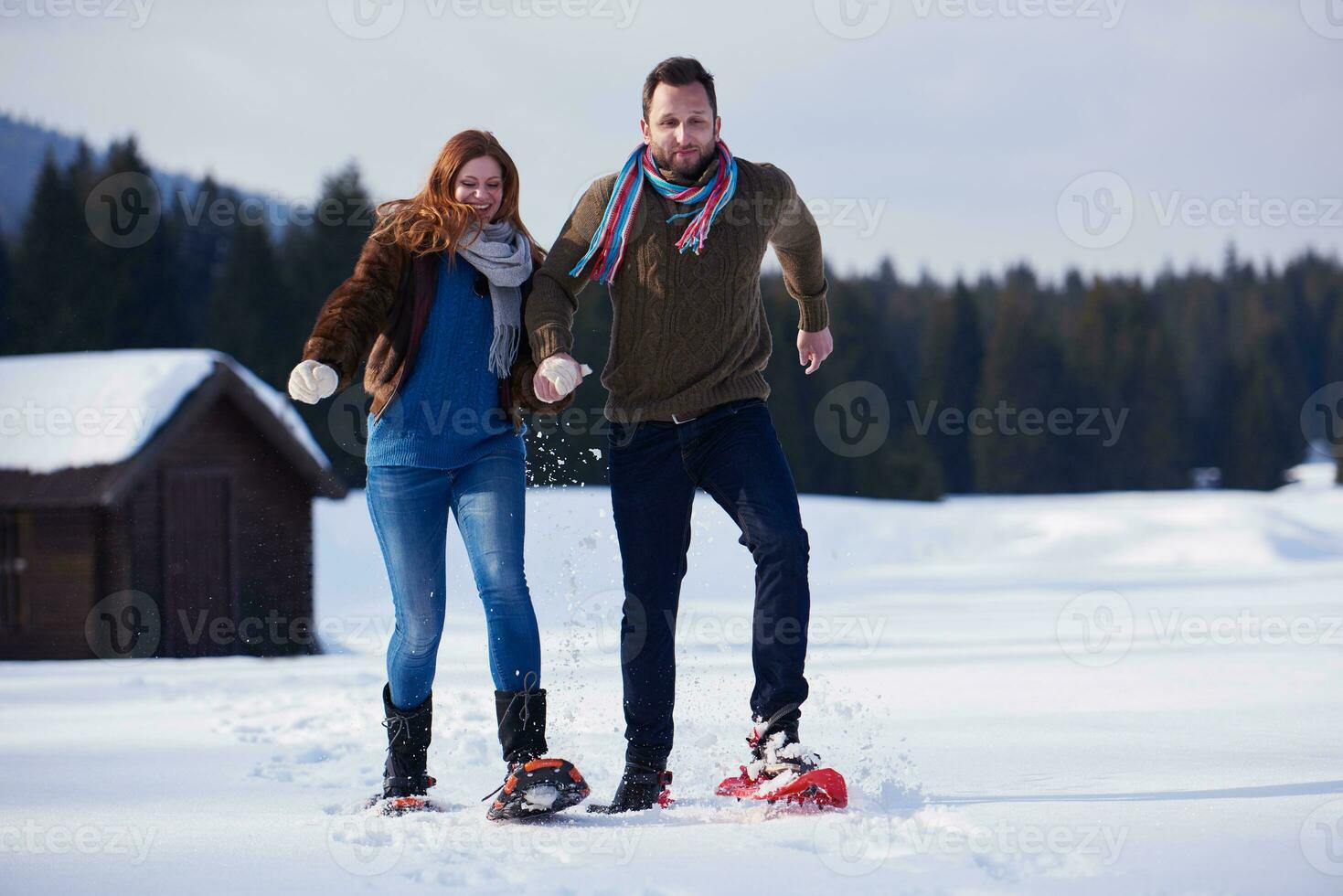 couple having fun and walking in snow shoes photo