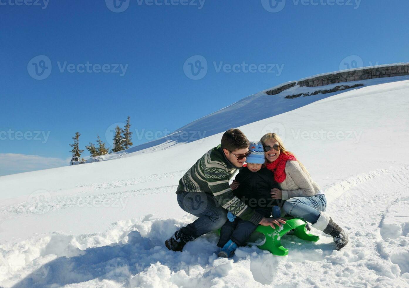 family having fun on fresh snow at winter vacation photo