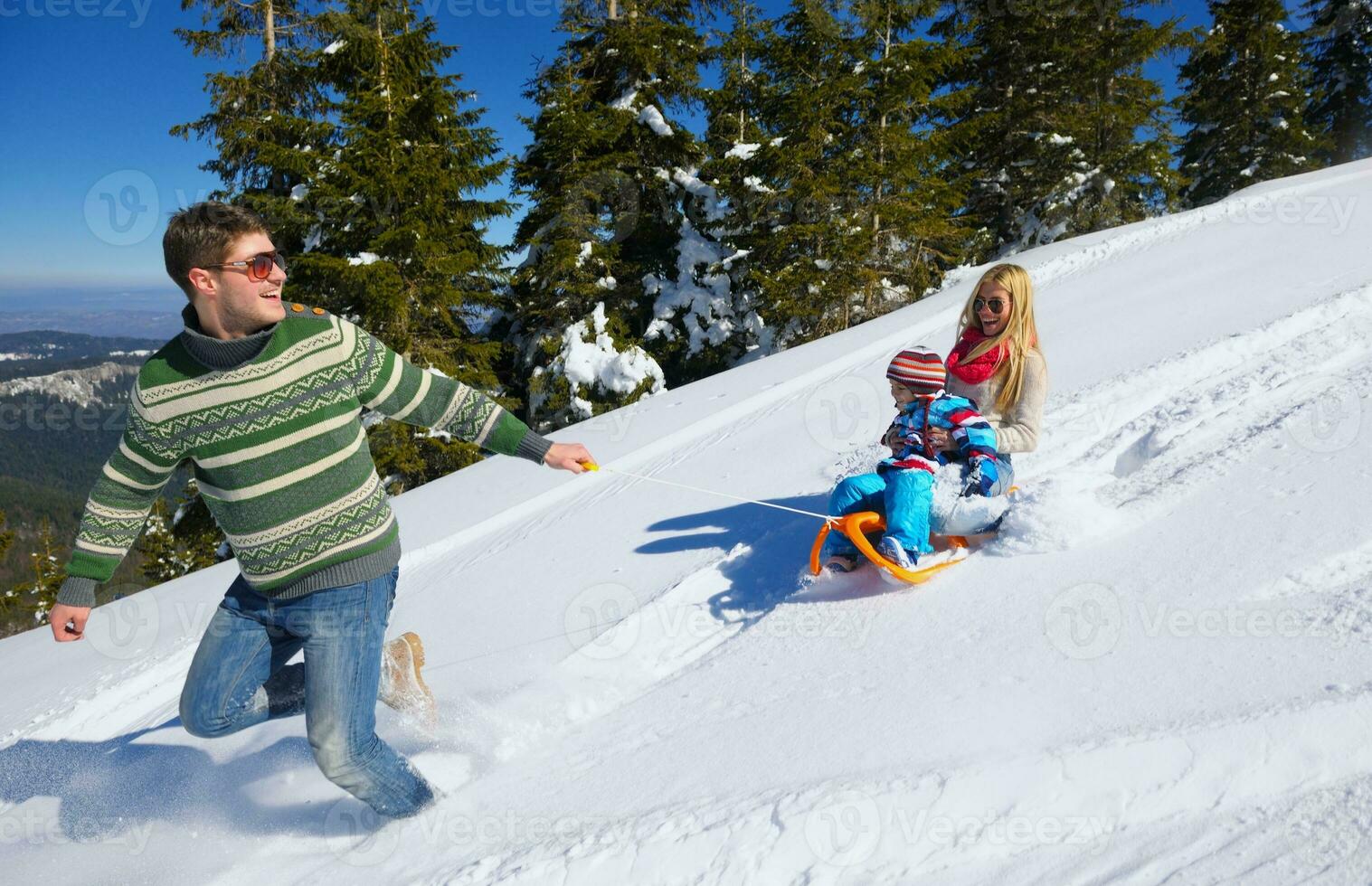 family having fun on fresh snow at winter photo