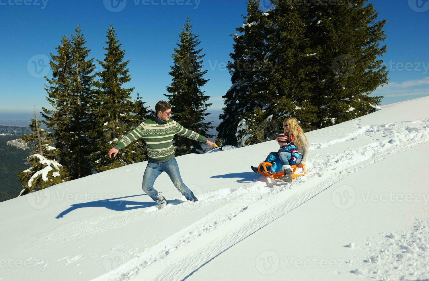 family having fun on fresh snow at winter photo