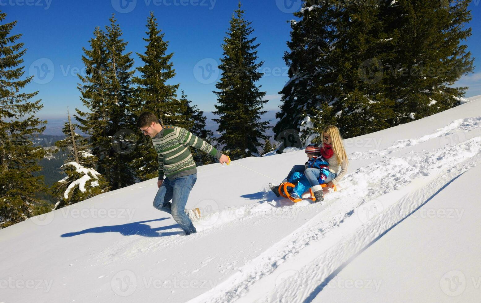 family having fun on fresh snow at winter vacation photo