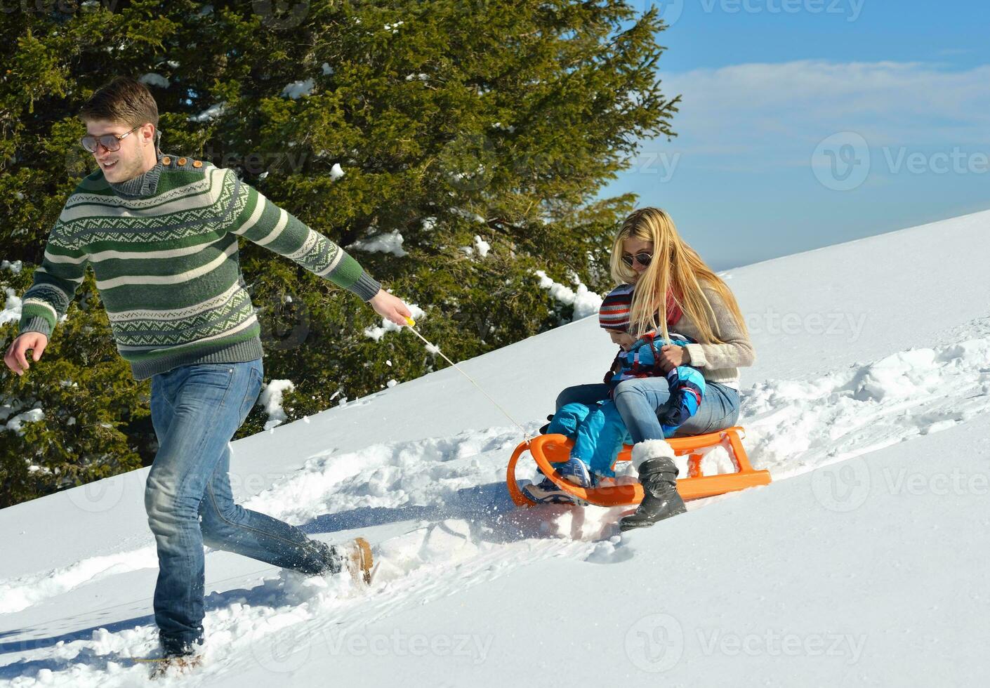 family having fun on fresh snow at winter vacation photo