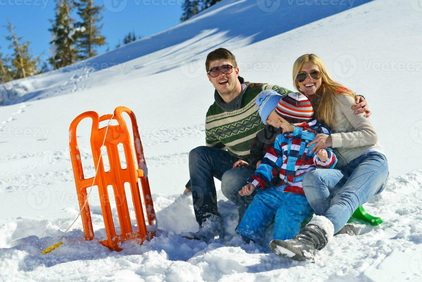 family having fun on fresh snow at winter vacation photo