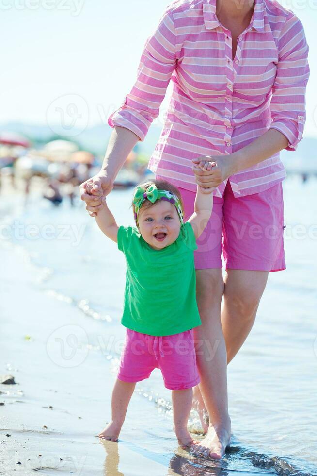 mamá y bebé en la playa se divierten foto