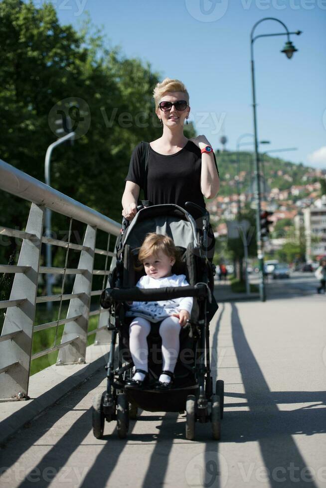 mother pushed her baby daughter in a stroller photo