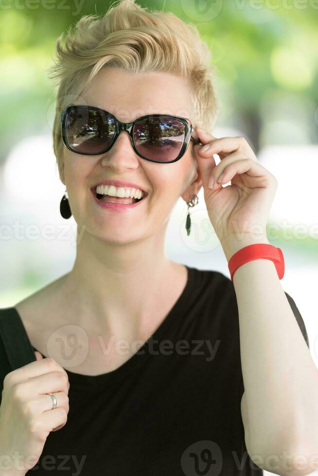 mujer joven con cabello rubio corto y gafas de sol foto