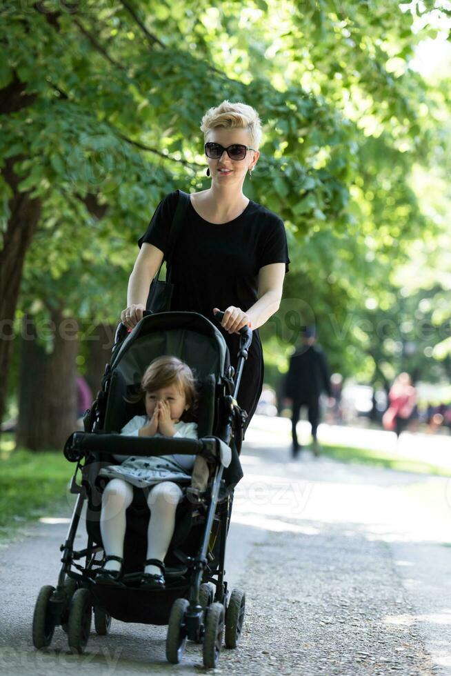 mother pushed her baby daughter in a stroller photo