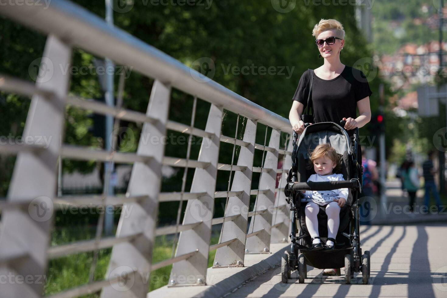 mother pushed her baby daughter in a stroller photo