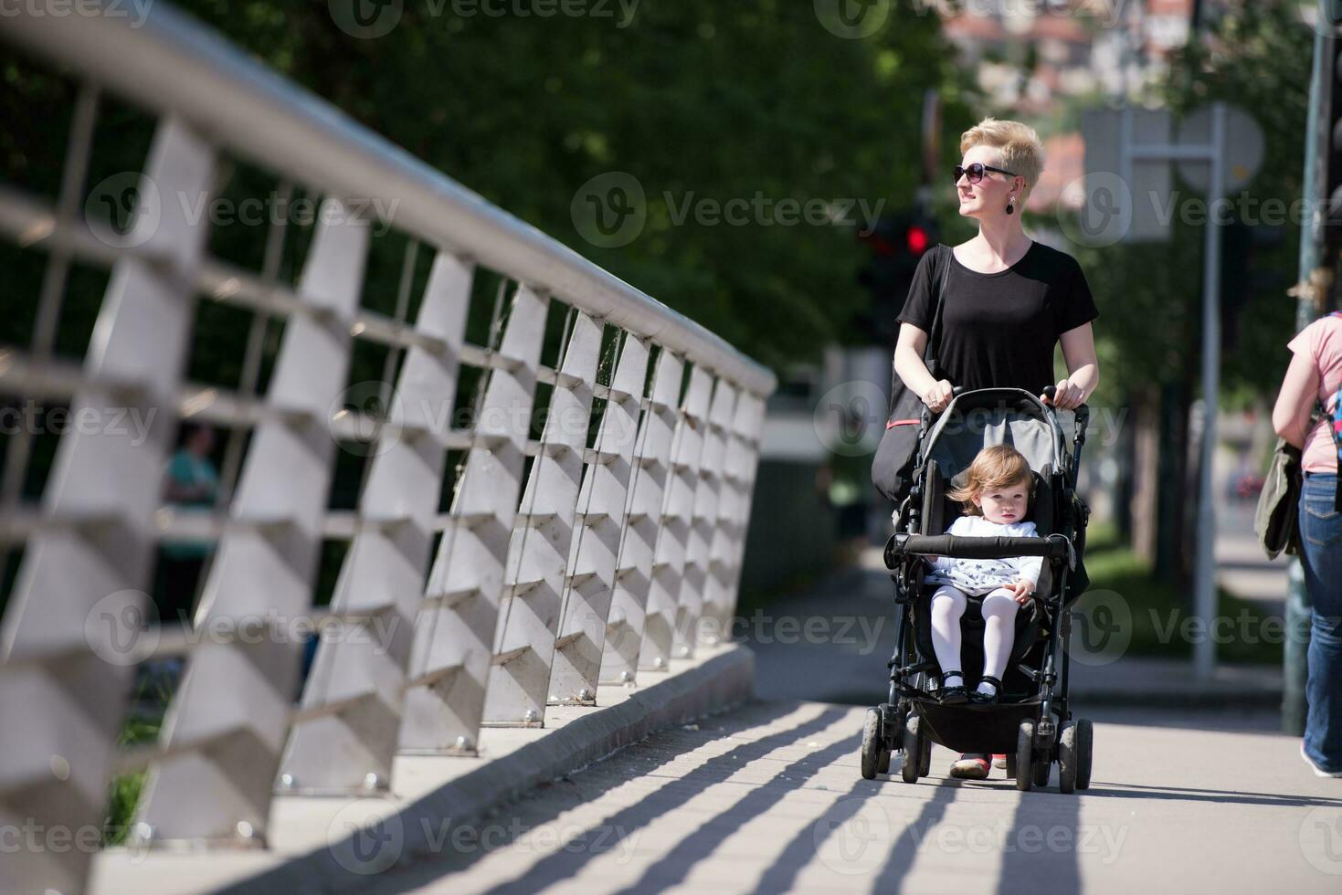 mother pushed her baby daughter in a stroller photo