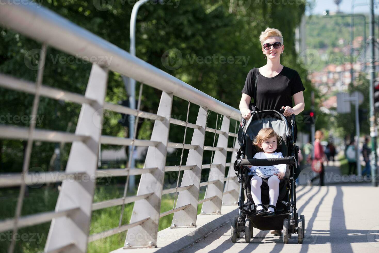 mother pushed her baby daughter in a stroller photo