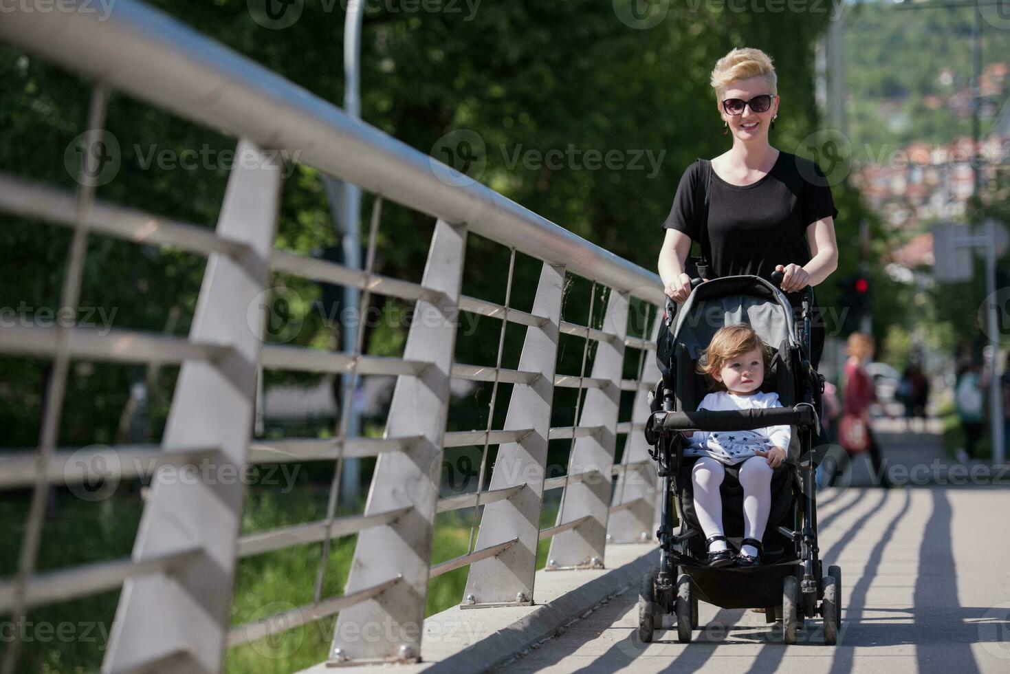 mother pushed her baby daughter in a stroller photo