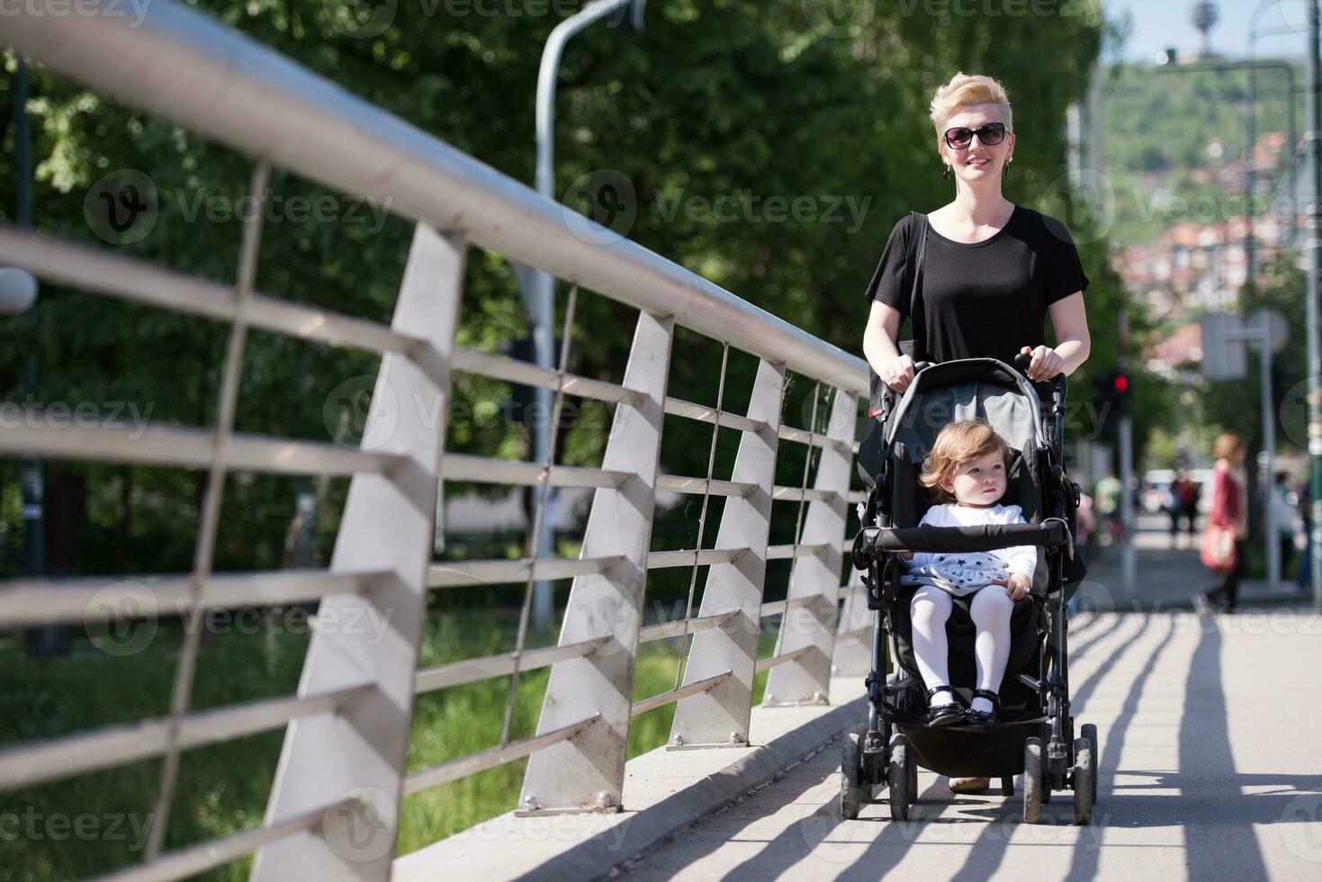 mother pushed her baby daughter in a stroller photo