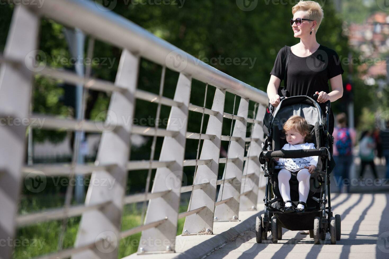 mother pushed her baby daughter in a stroller photo