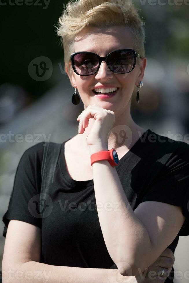 mujer joven con cabello rubio corto y gafas de sol foto