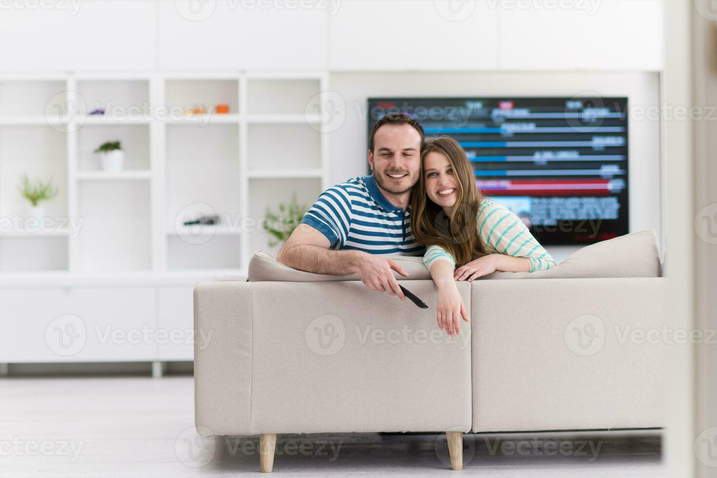 pareja joven en el sofá viendo la televisión foto