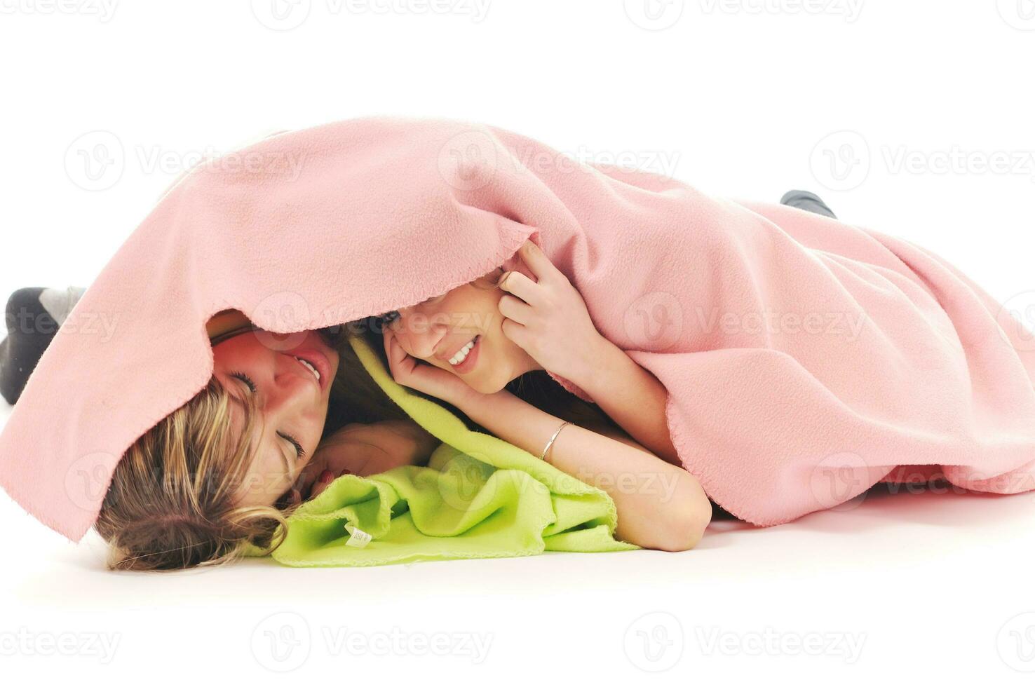 young girls under blanket smile photo