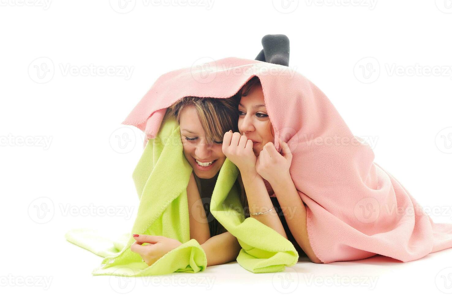 young girls under blanket smile photo