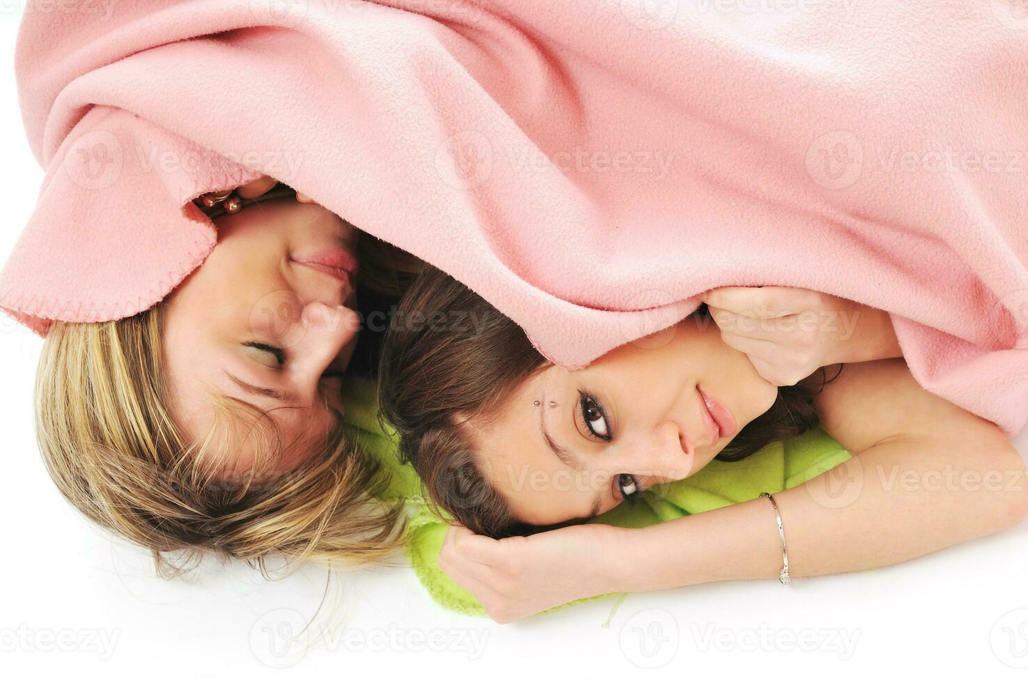 young girls under blanket smile photo
