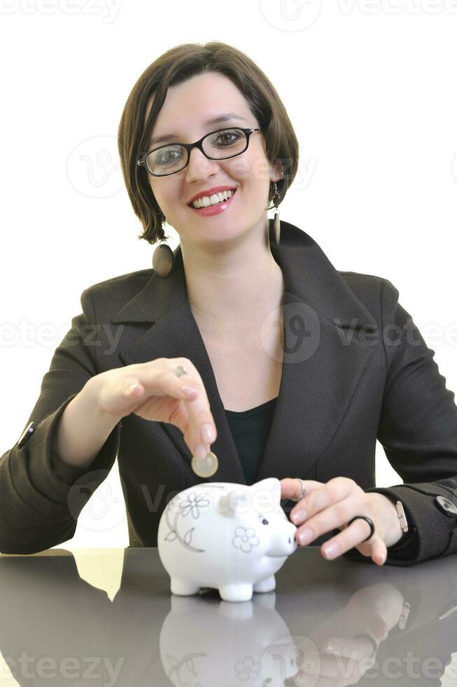 business woman putting money coins in piggy bank photo