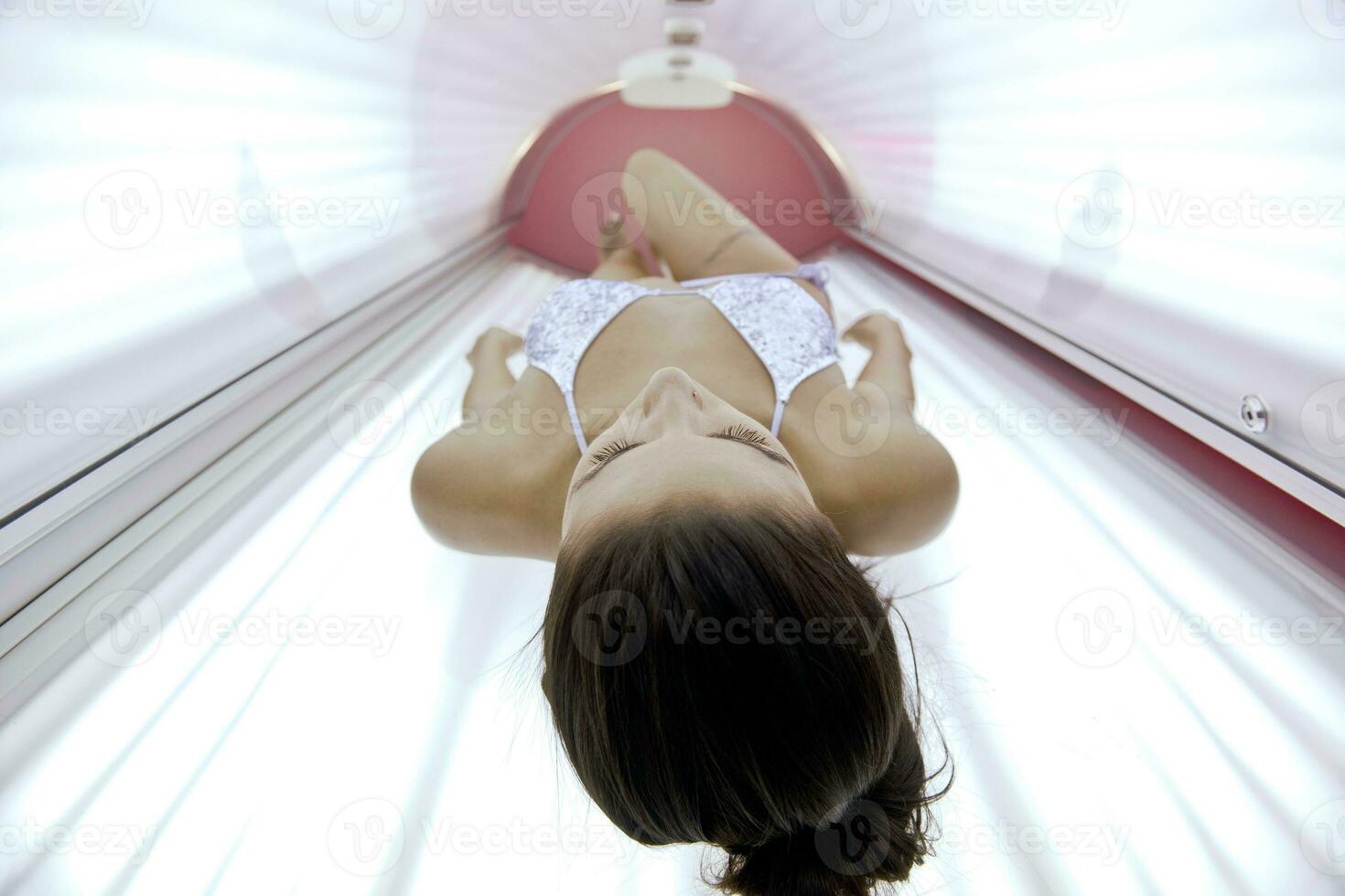 bella joven bronceándose en el solarium foto