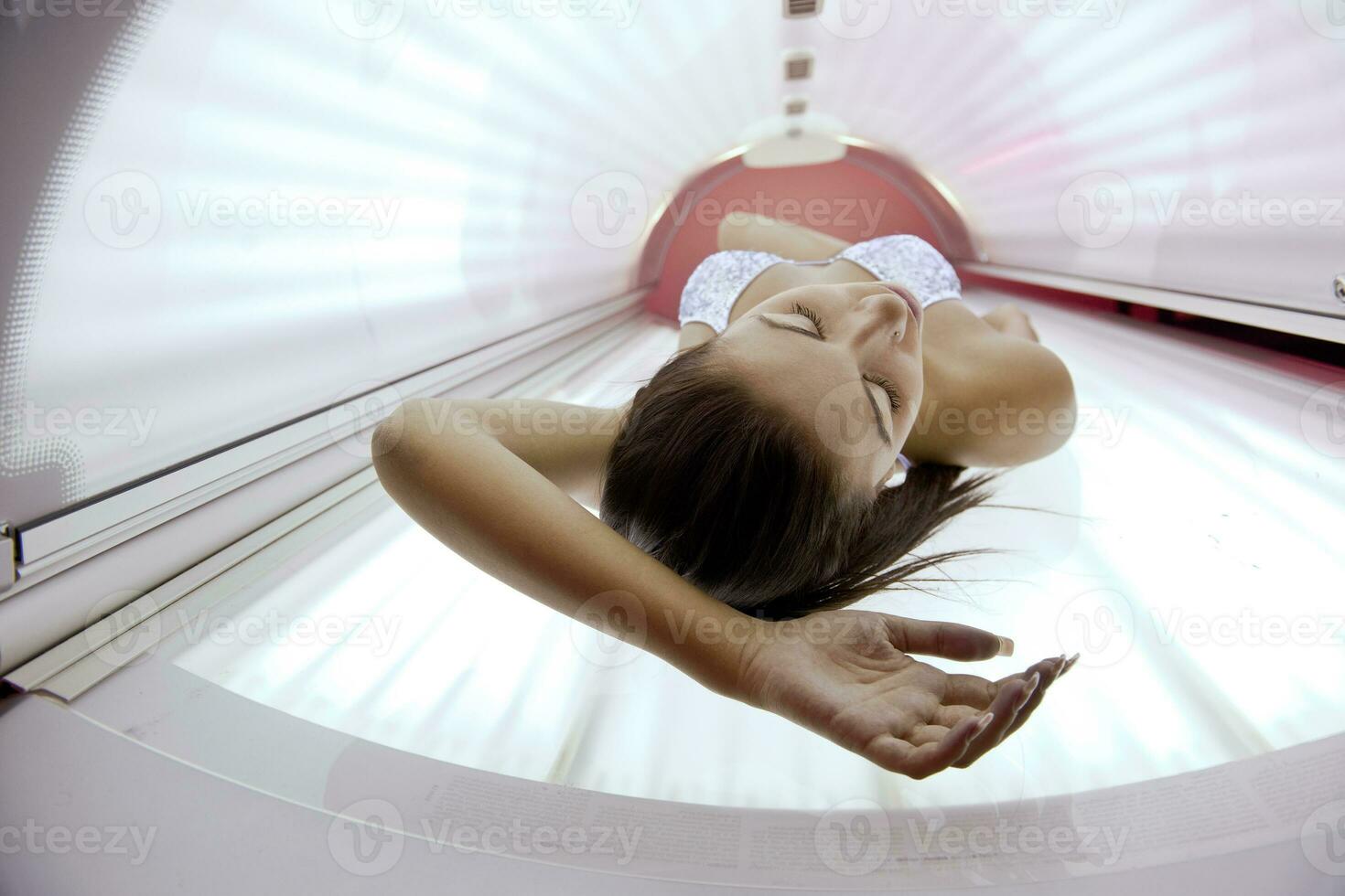 bella joven bronceándose en el solarium foto