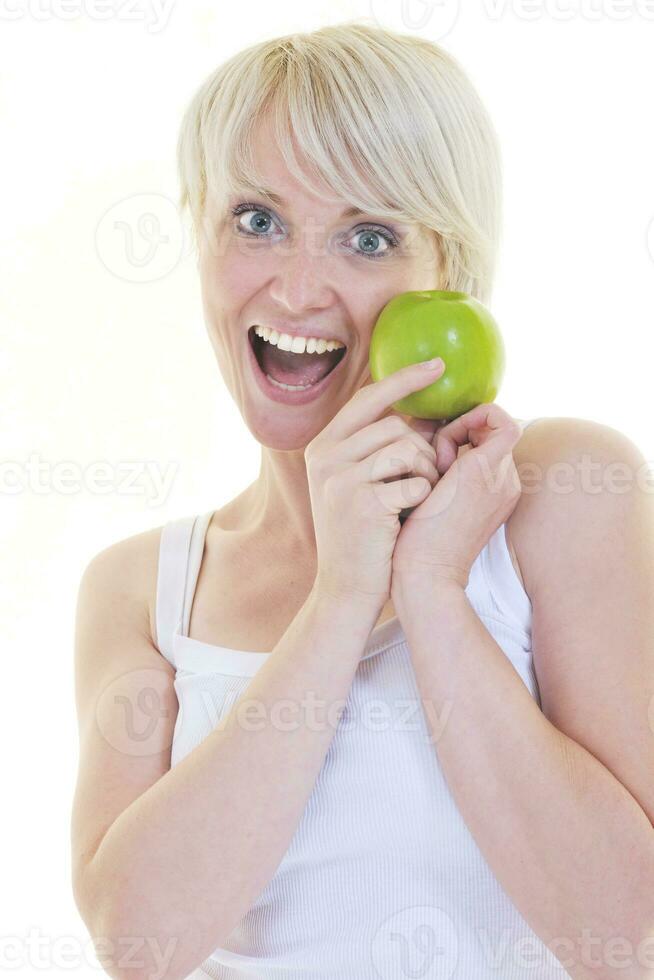 una joven feliz come manzana verde aislada en blanco foto