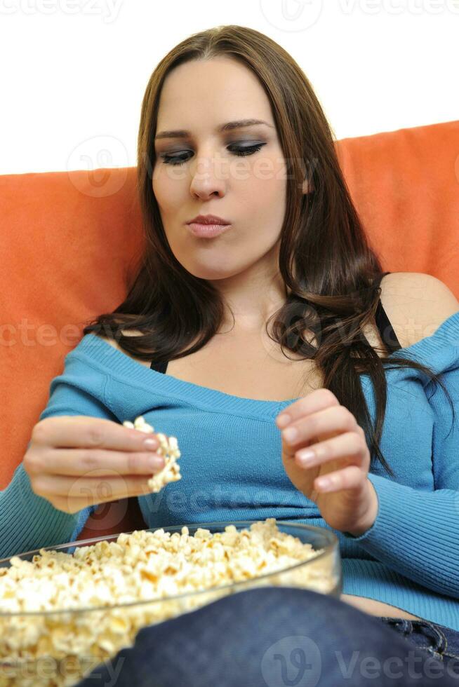 young woman eat popcorn and watching tv photo