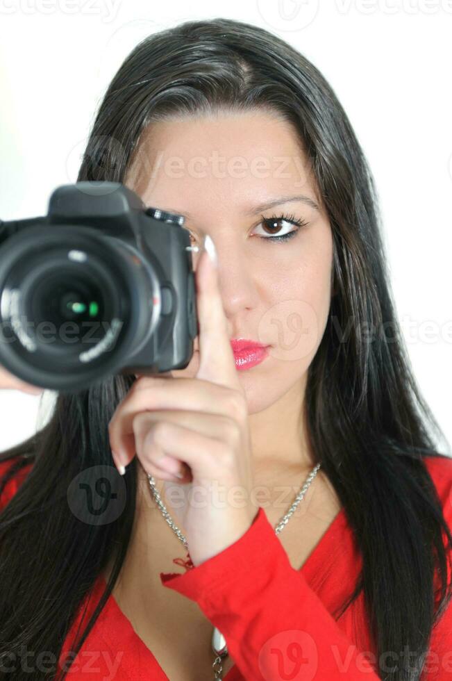 mujer joven sosteniendo una cámara en la mano tomando una foto aislada