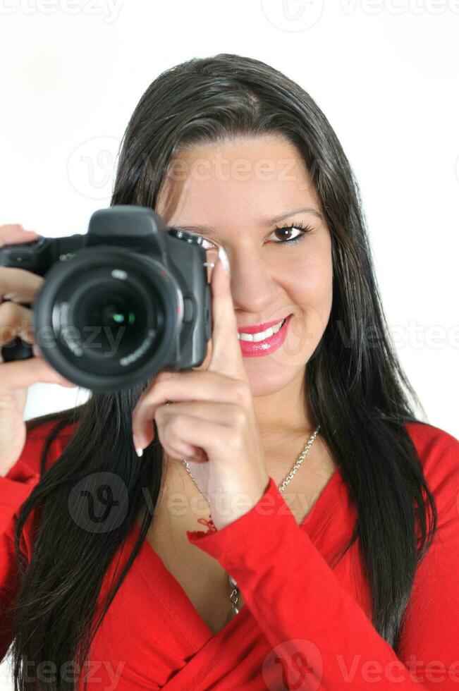 mujer joven sosteniendo una cámara en la mano tomando una foto aislada