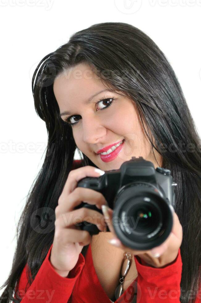 mujer joven sosteniendo una cámara en la mano tomando una foto aislada