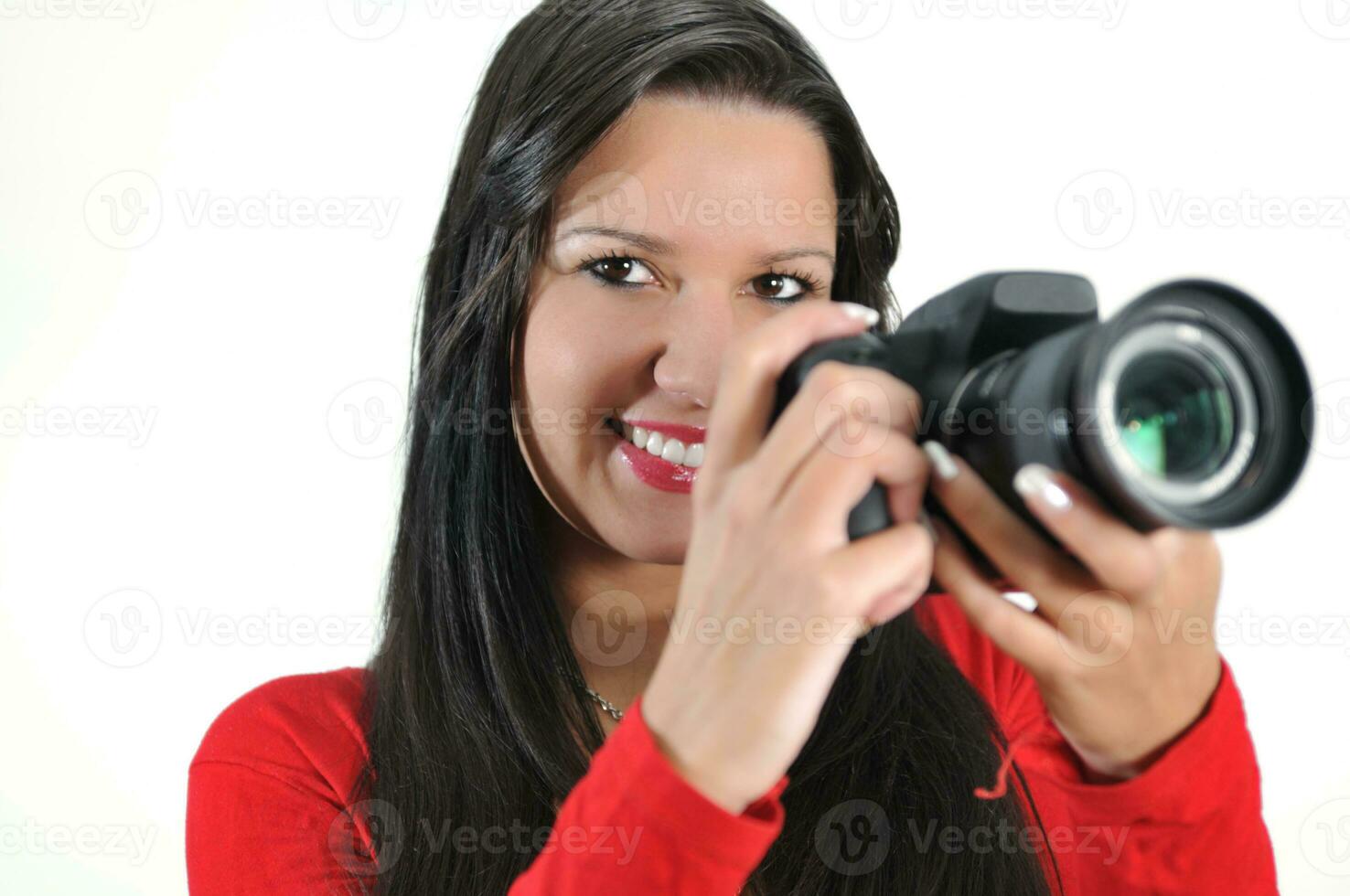 mujer joven sosteniendo una cámara en la mano tomando una foto aislada