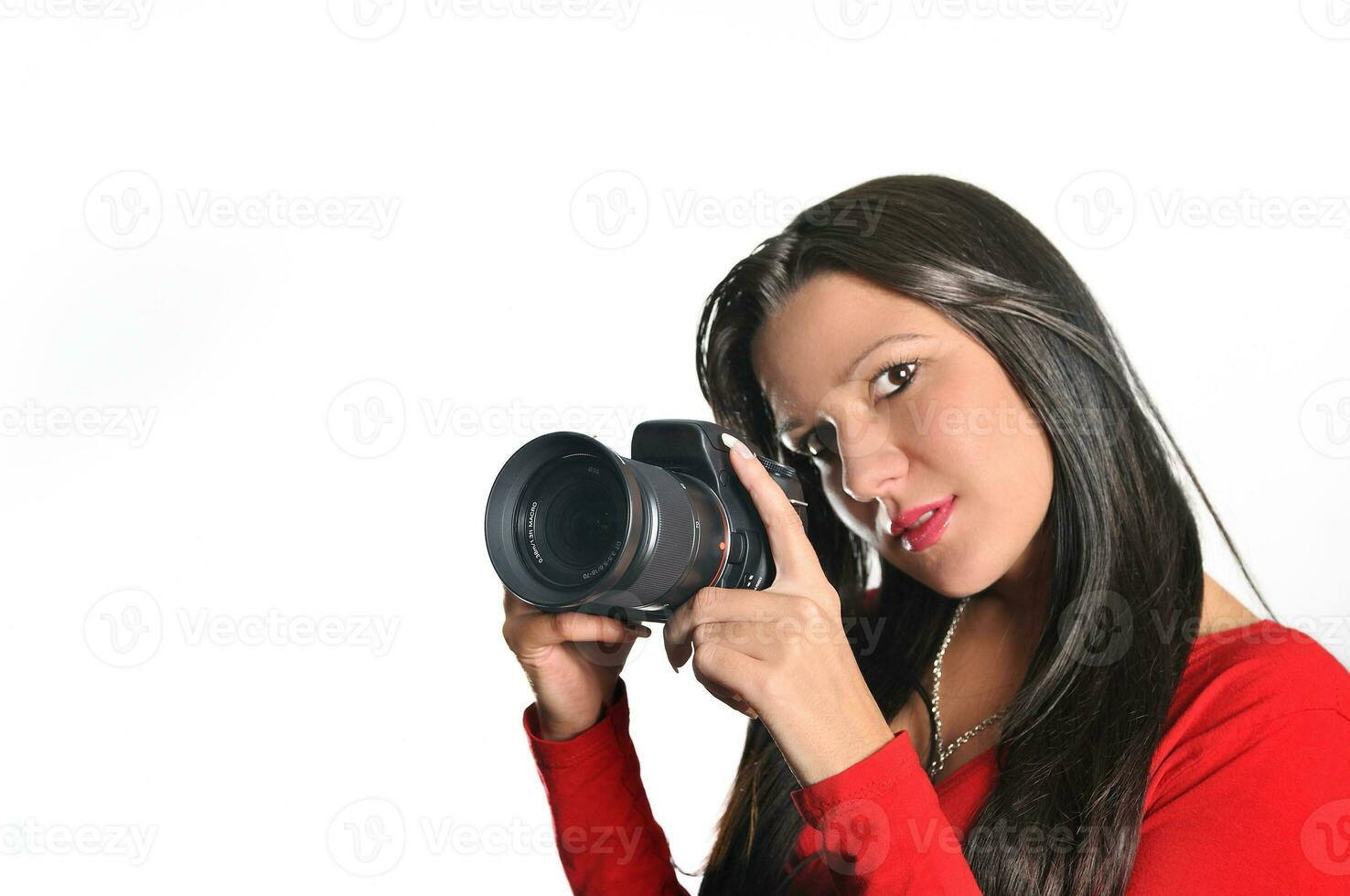 mujer joven sosteniendo una cámara en la mano tomando una foto aislada