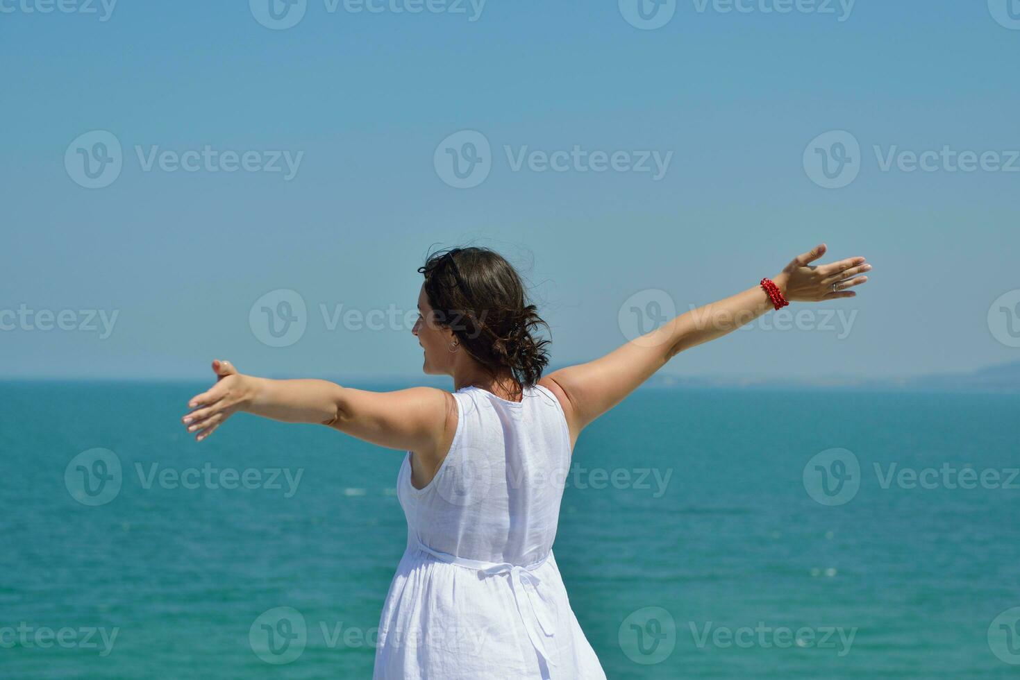 happy young woman with spreading arms to sky photo