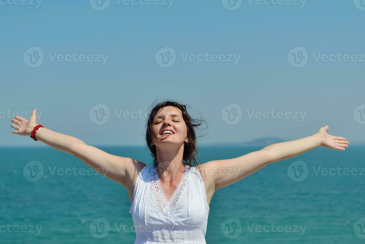 happy young woman with spreading arms to sky photo