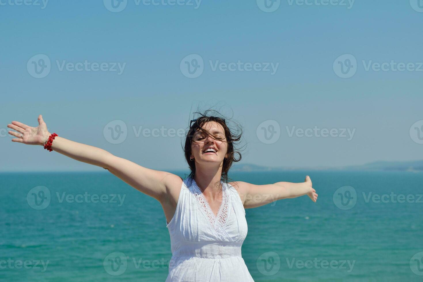 happy young woman with spreading arms to sky photo