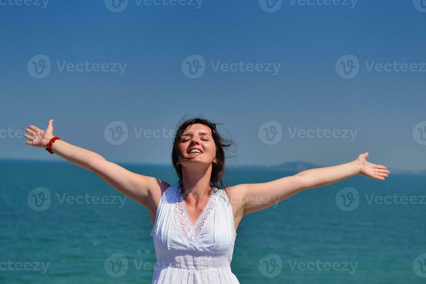 young woman with spreading arms to sky photo