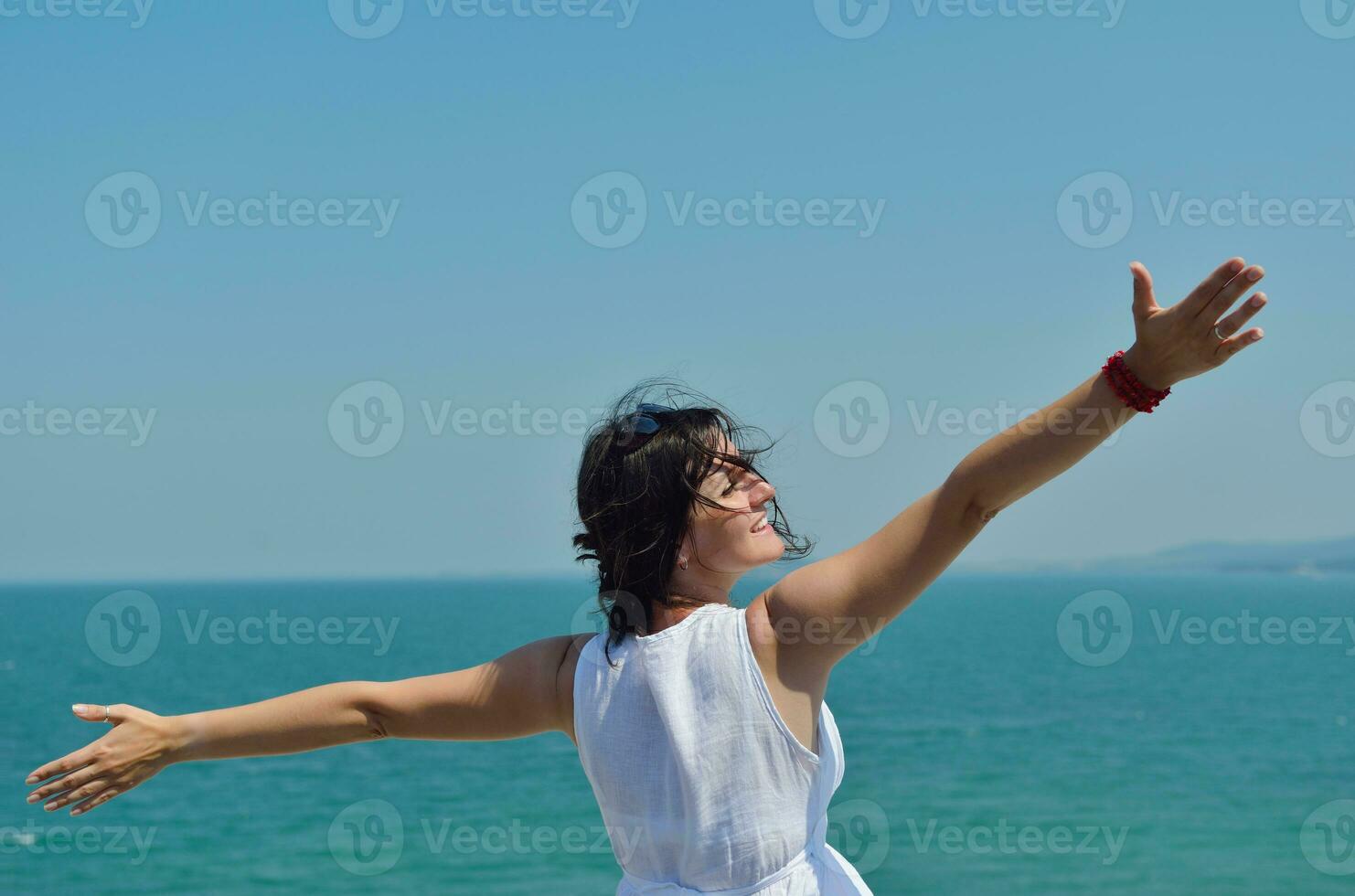 happy young woman with spreading arms to sky photo