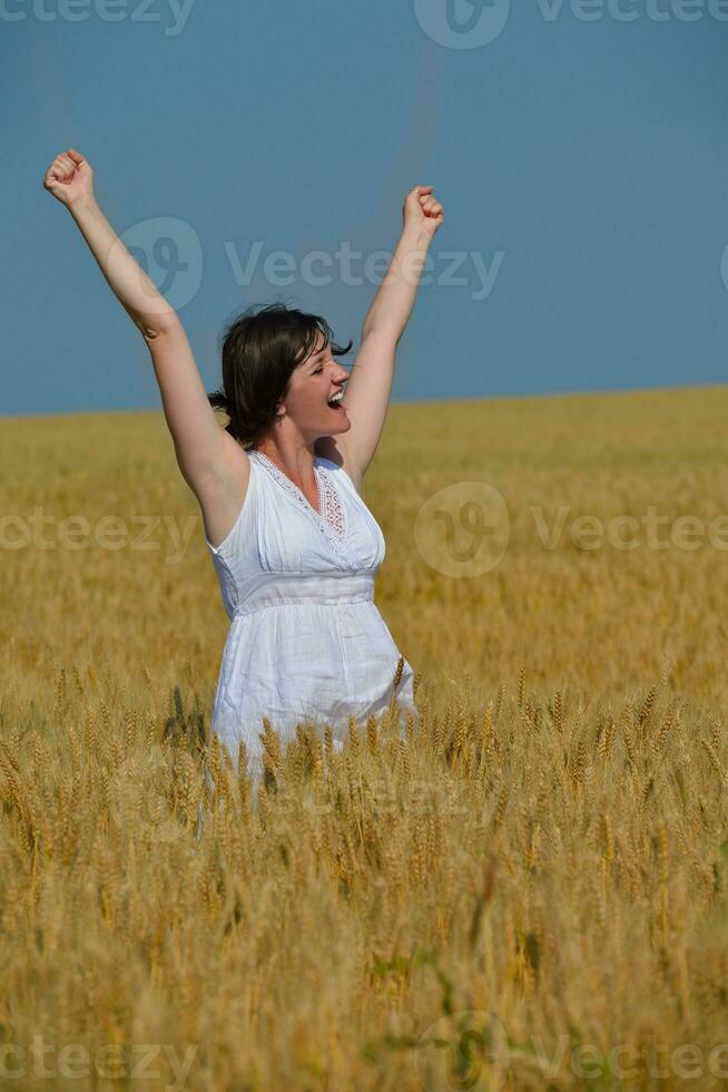 mujer joven en campo de trigo en verano foto