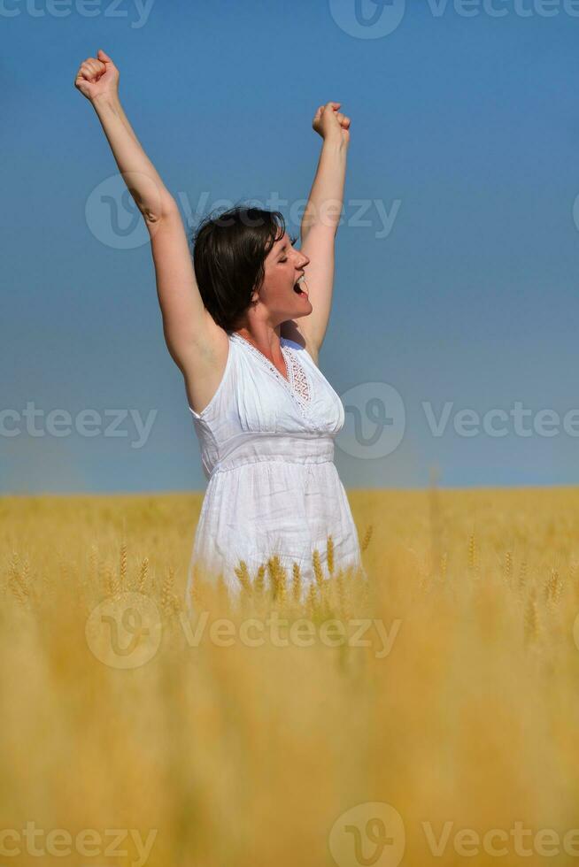 mujer joven en campo de trigo en verano foto