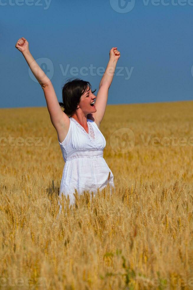 mujer joven en campo de trigo en verano foto