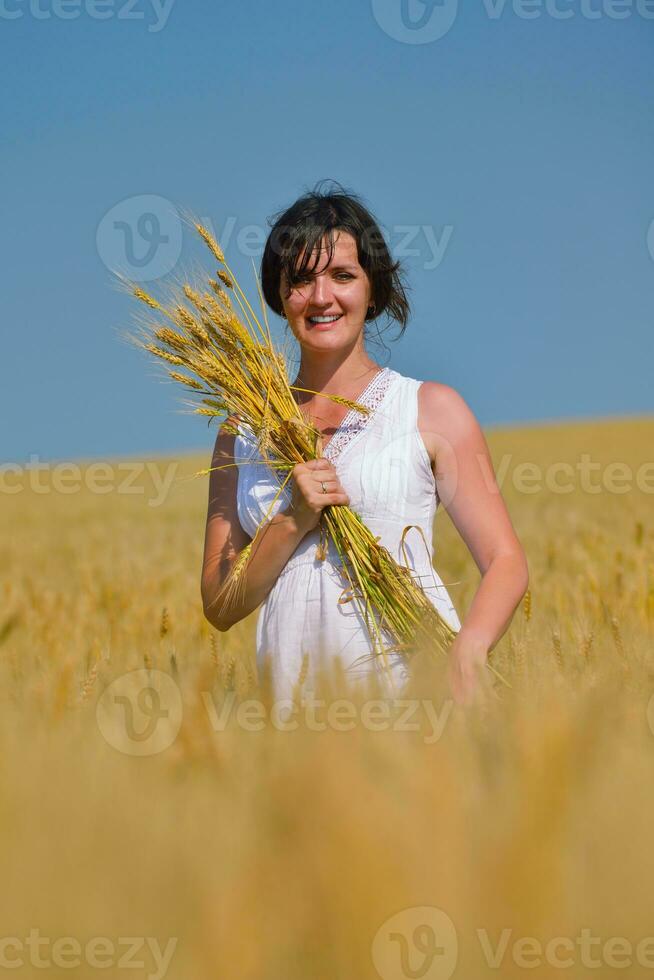 mujer joven en campo de trigo en verano foto