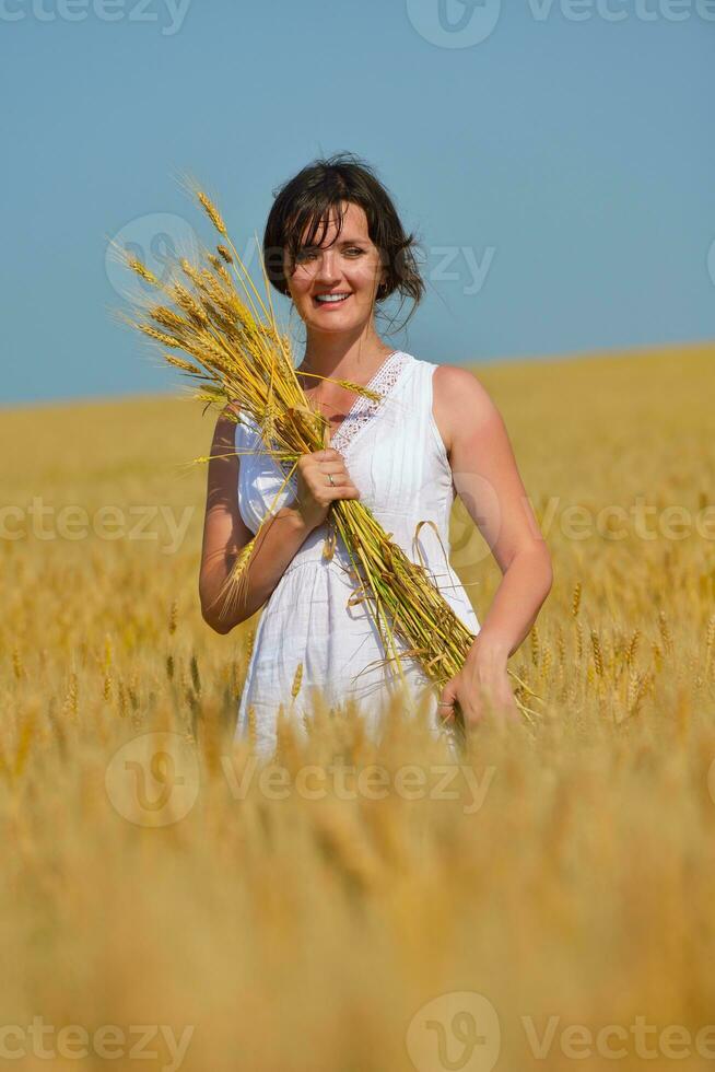 mujer joven en campo de trigo en verano foto