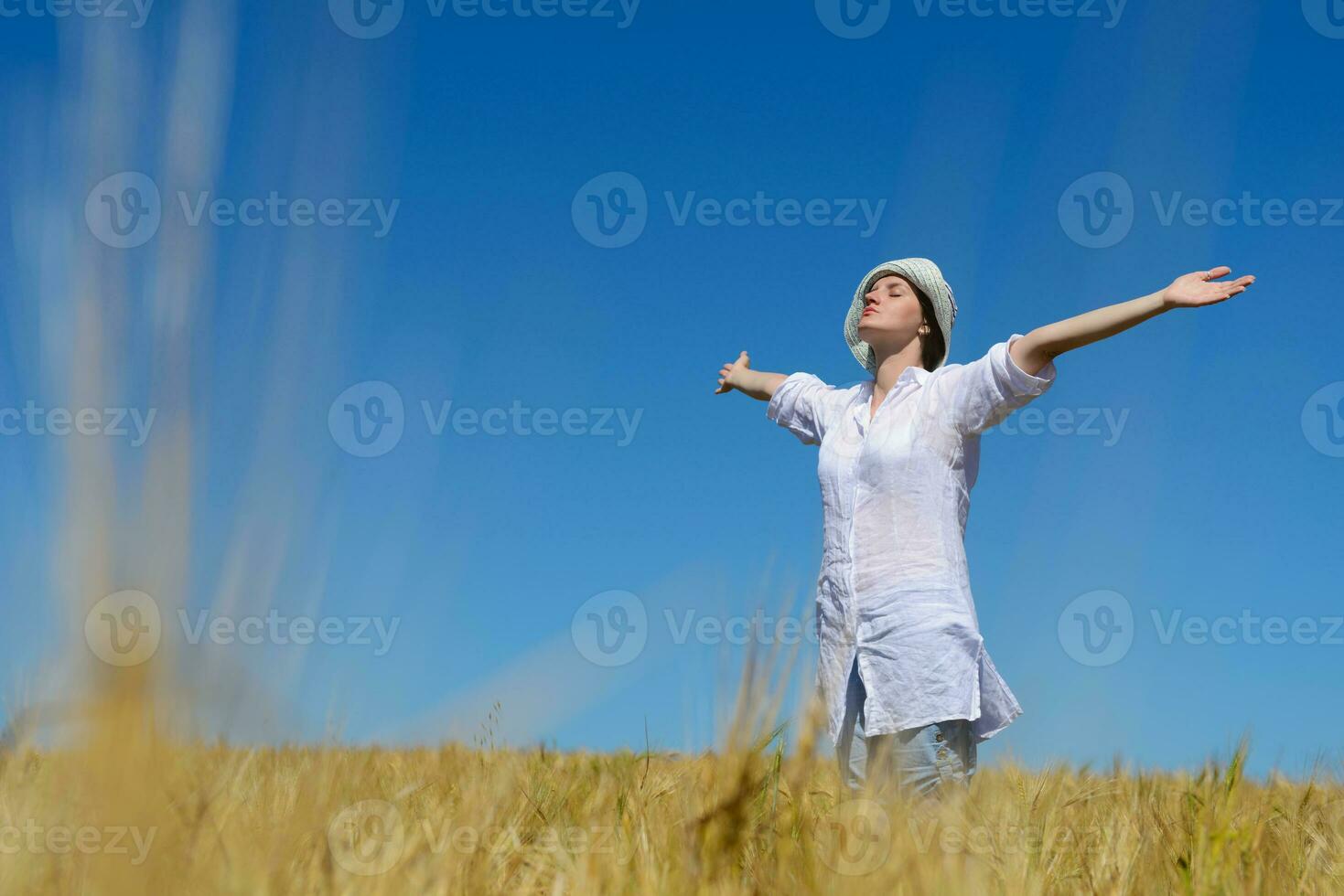 mujer joven en campo de trigo en verano foto