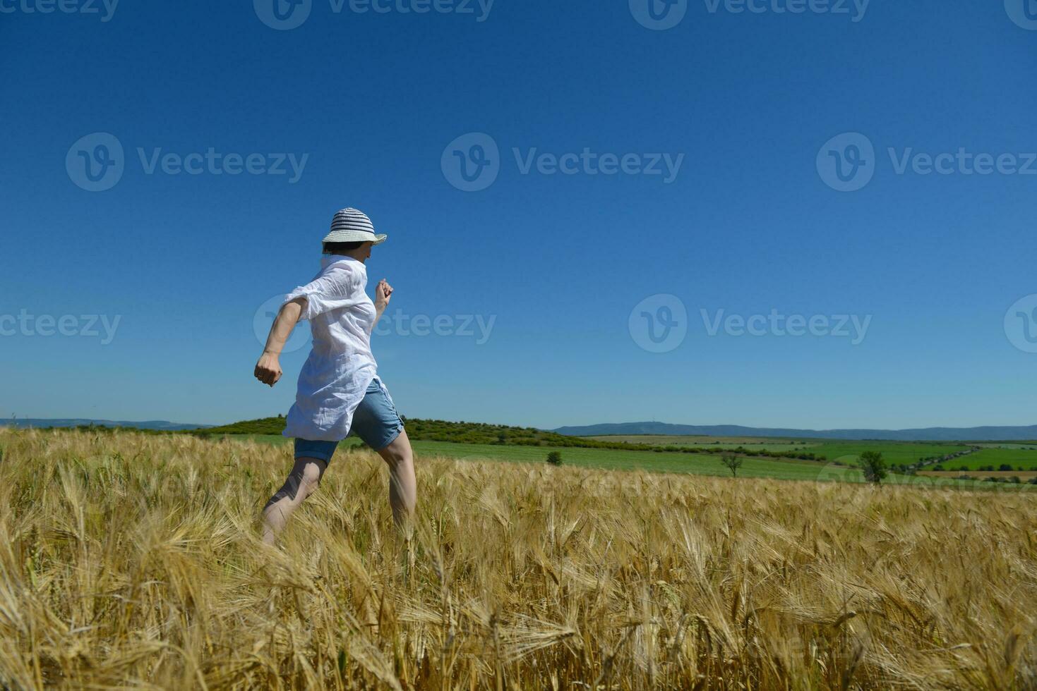 mujer joven en campo de trigo en verano foto