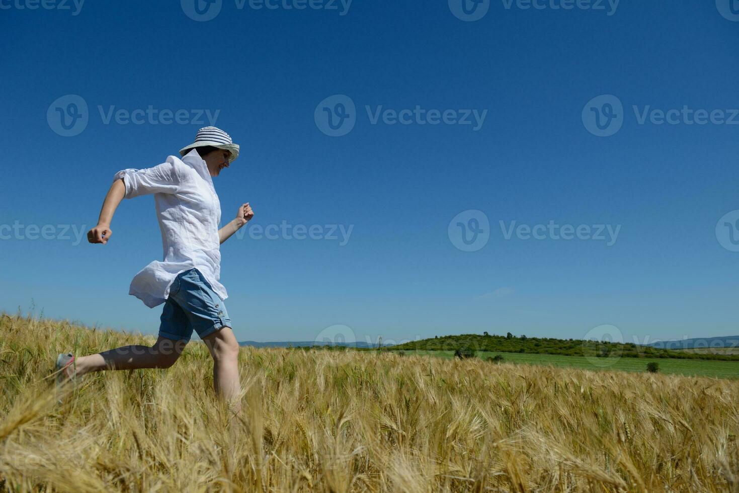 mujer joven en campo de trigo en verano foto