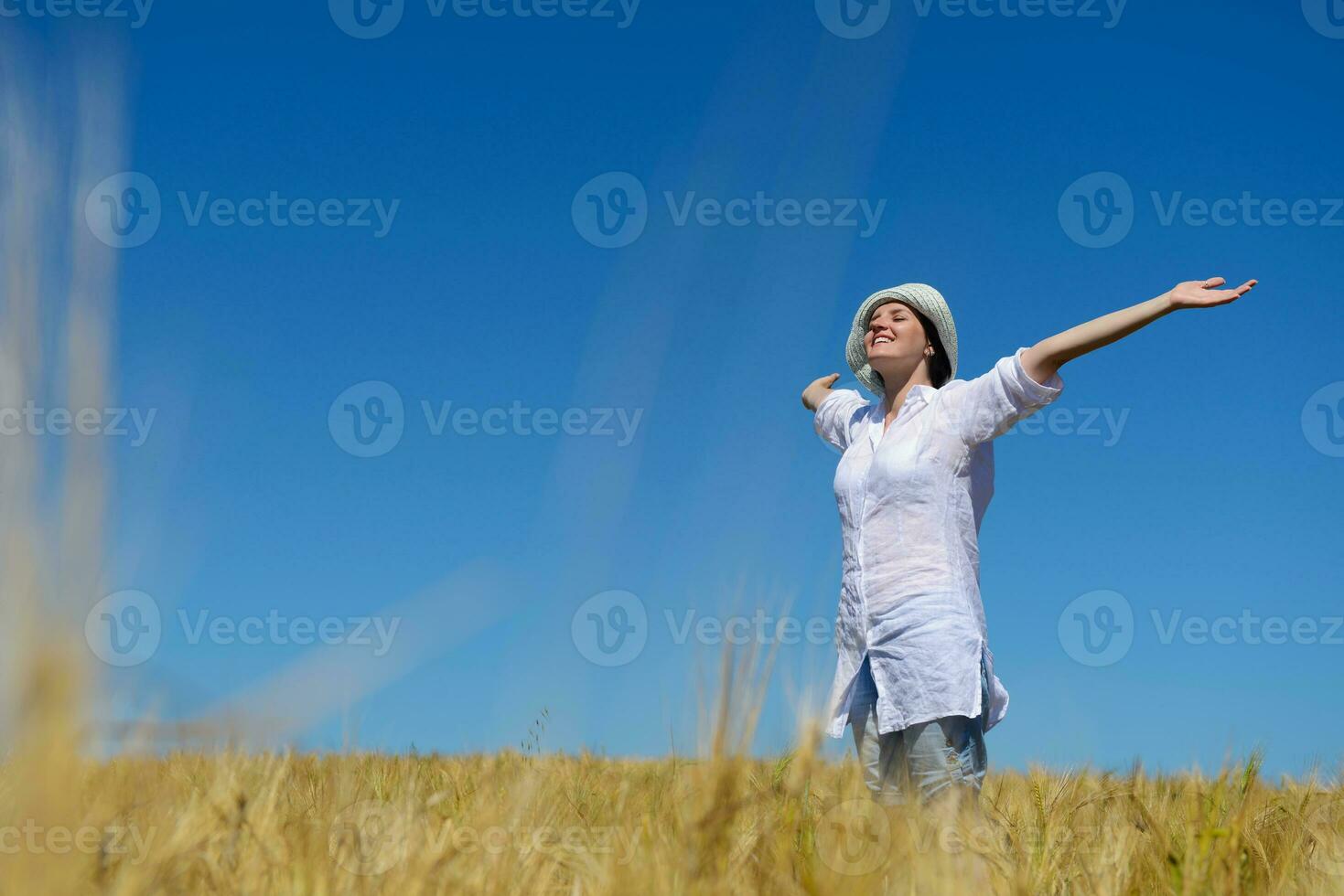 mujer joven en campo de trigo en verano foto